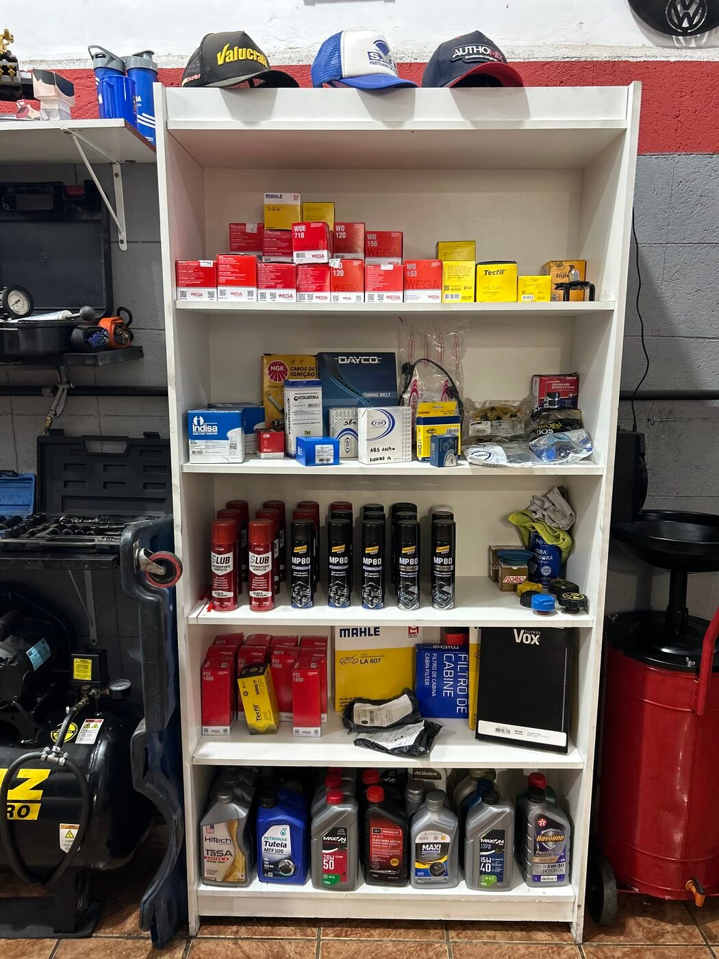 Prateleira organizada com óleos lubrificantes, filtros e produtos automotivos