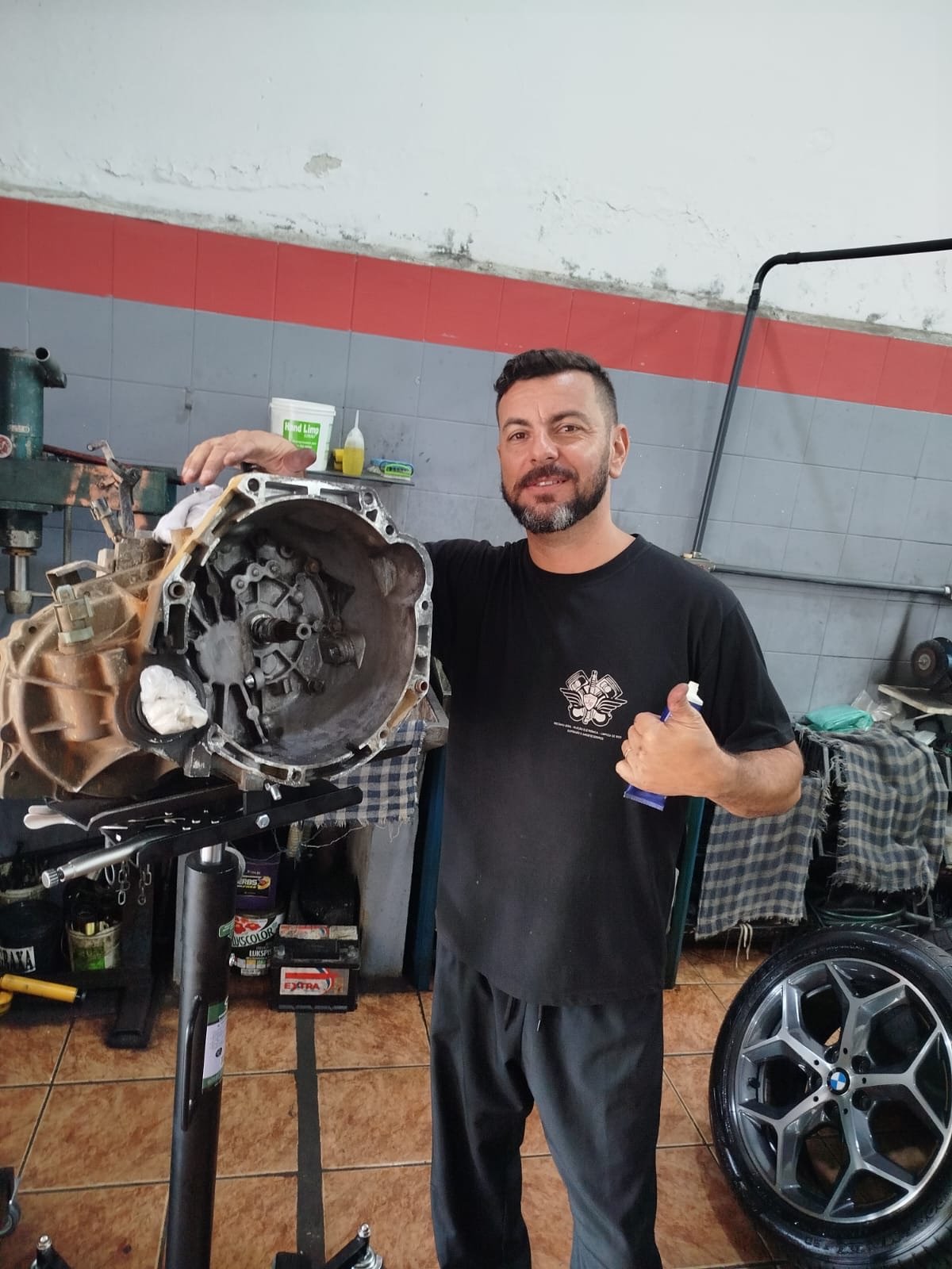 Juliano Roque ao lado de uma transmissão automotiva desmontada
