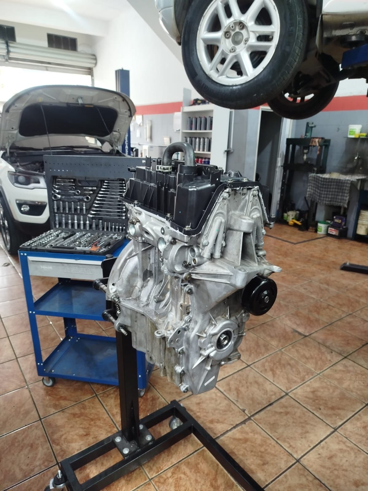 Motor automotivo montado em suporte de bancada dentro da oficina